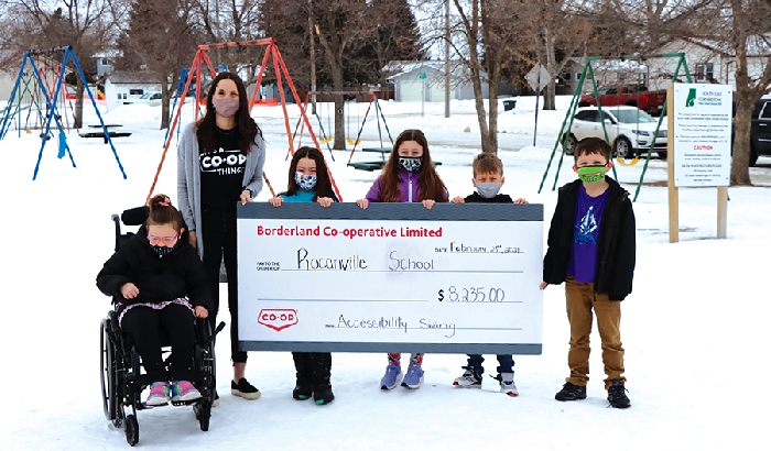 Borderland Co-op Community Relations Manager Savannah Roden presents Rocanville School students (left to right) Sofia Laidlaw, Lilly Jackson, Ella Bock, Corbin Minty, and Odin Rosti with a cheque for $8,235 to go towards the school’s wheelchair swing project.