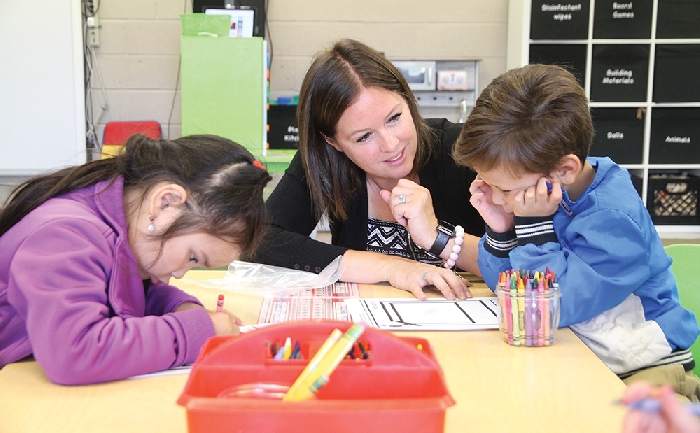 Students were back to school last week as classes resumed for the 2019-20 school year. Above, Mrs. McMullen at MacLeod Elementary School in Moosomin teaches Kindergarten students Marjela and Liam how to draw a picture of themselves and write their names on their first day of school.