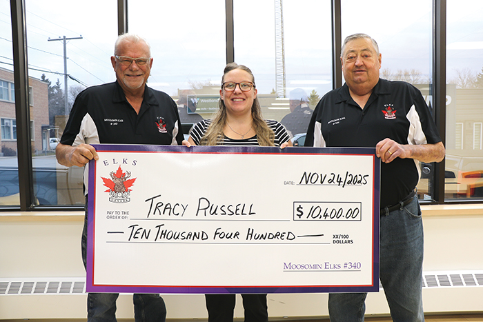 Ron Potter, left, and Larry Tomlinson, right, with the Moosomin Elks presenting Tracy Russell with her 50/50 winnings last week.></a><br />
<p class=