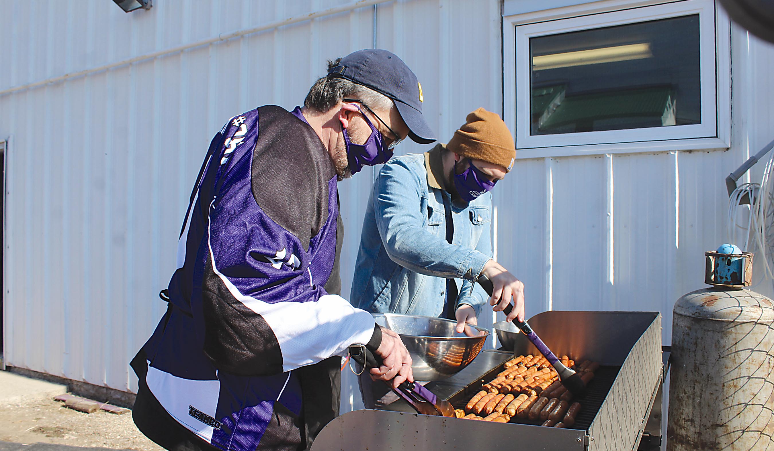 Ken Shackle and Dane Kingdon busy cooking up 150 hot dogs at the recent Elks Drive By Lunch event in Elkhorn.