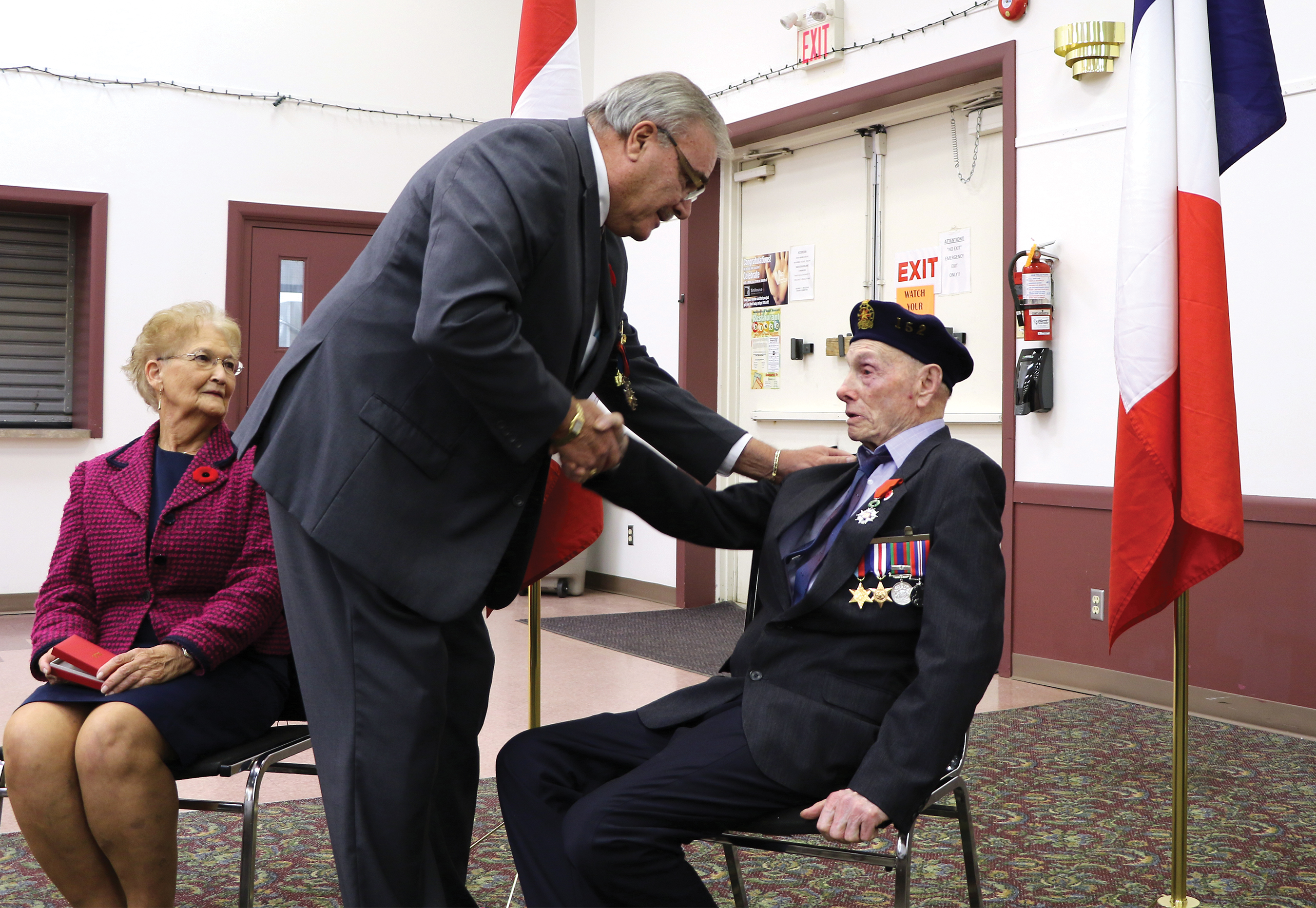 Lloyd Tibbats receives the French Legion of Honor from French Consul Bruno Burnichon.