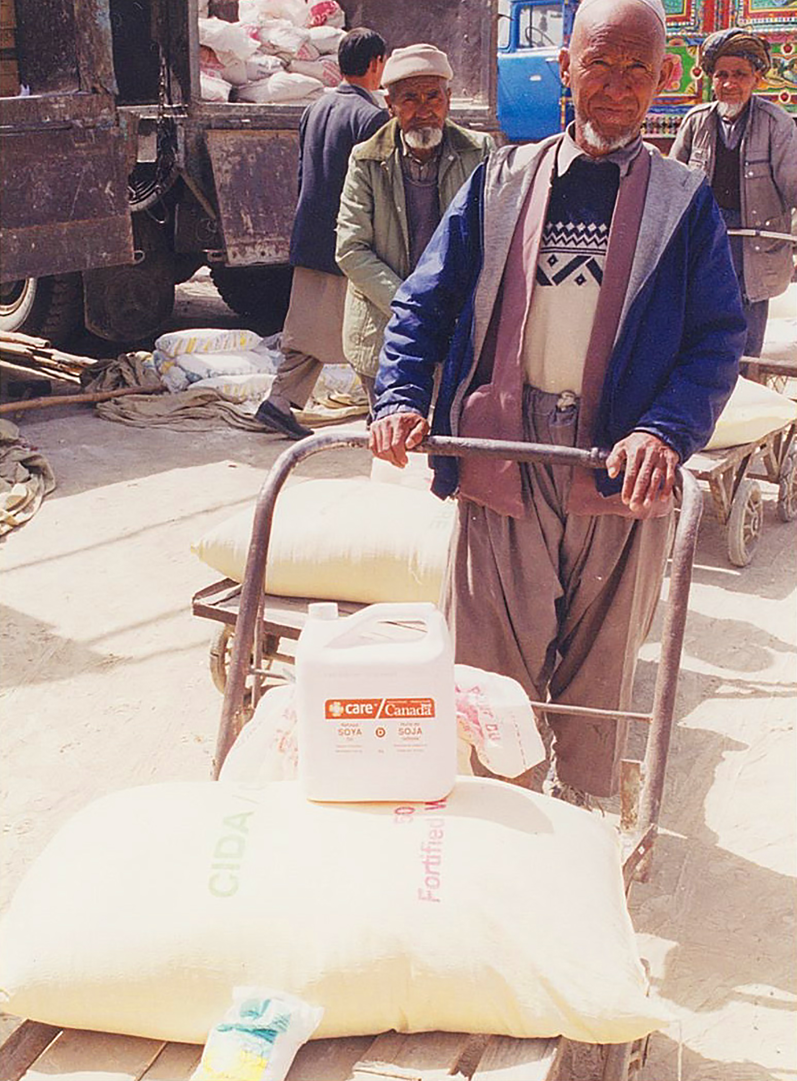 Kevin Weedmark took this photo in Aftghanistan while on a CIDA project. It shows volunteers distributing Canadian wheat, cooking oil, lentils, and iodized salt � food intended to keep a family alive for a month.