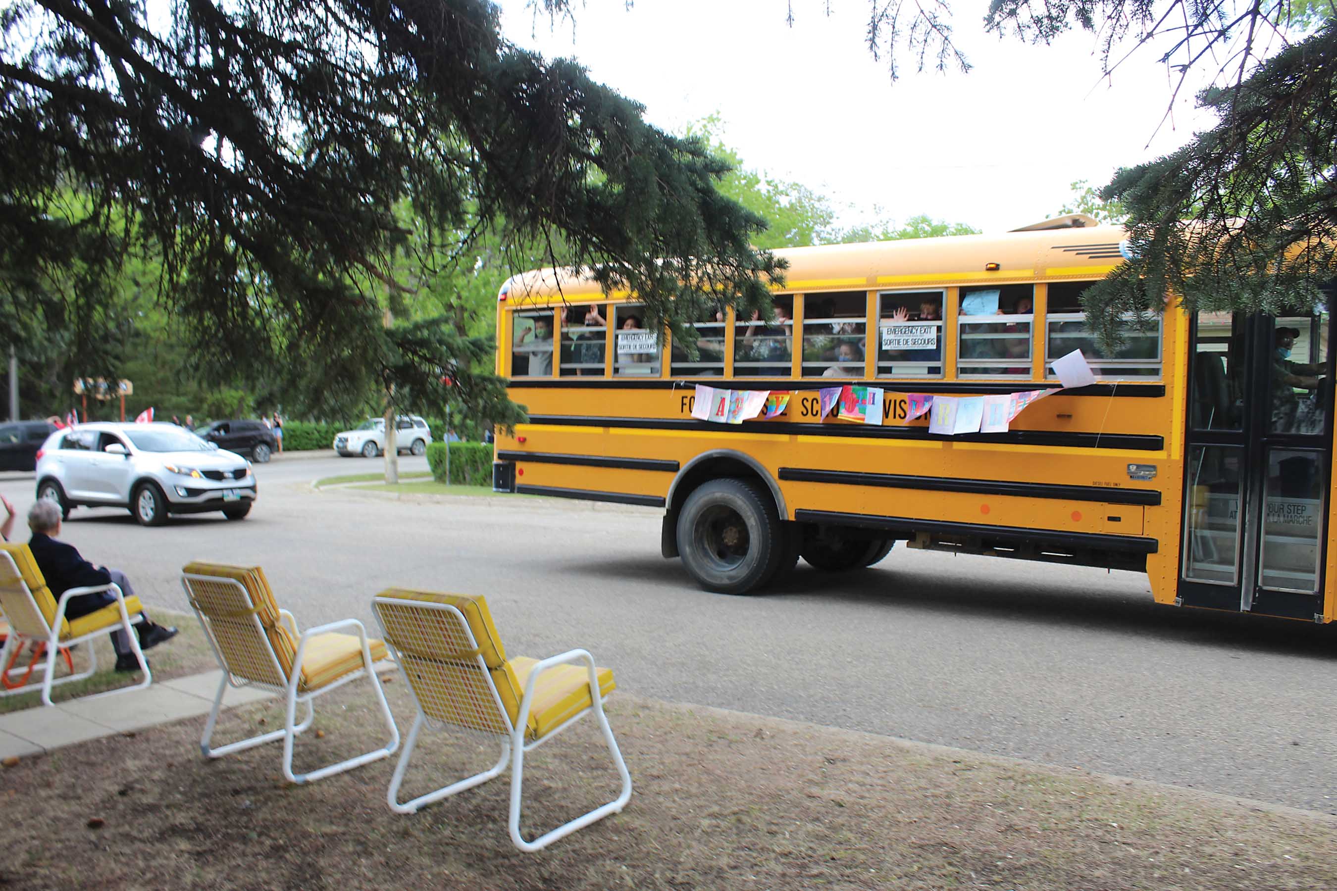 A school bus full of kids from Fort La Bosse School Division singing happy birthday to Les as they drive by.