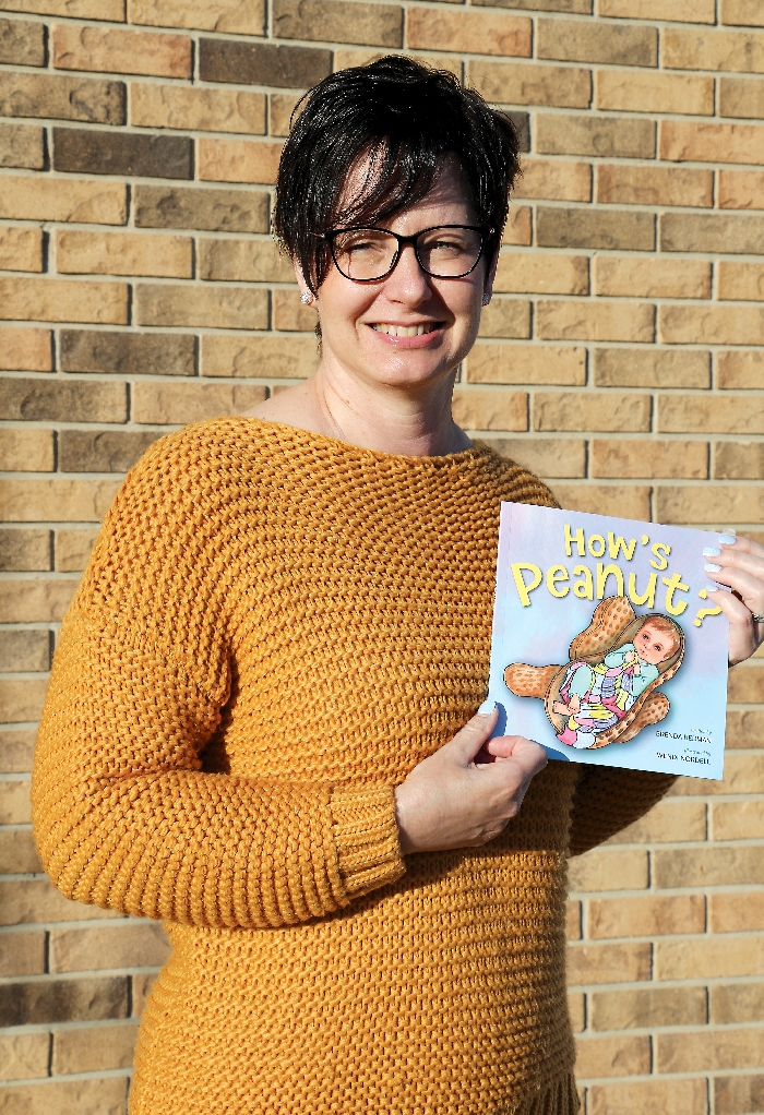Brenda Redman with her book. Redmans book uses repetition and compares the babys size to different kinds of fruit so that kids can learn from it as well as have fun reading it.
