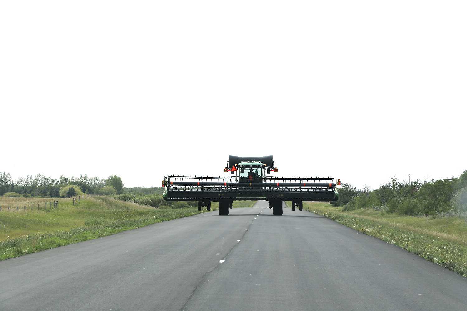 Sunnette Kamffer photo: A farmer moving a swather on the lake road south of Moosomin.