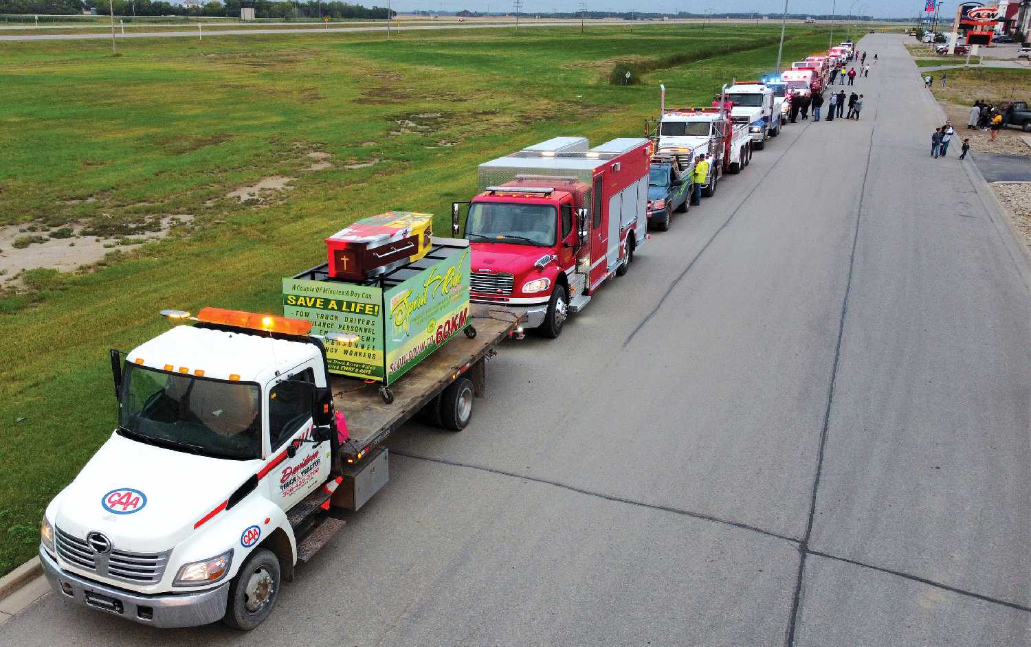 Tow truck and emergency vehicles lined up along Lake Avenue with their lights flashing on Wednesday for the blue lights and burgers event.